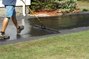 Worker Applying Driveway Sealer